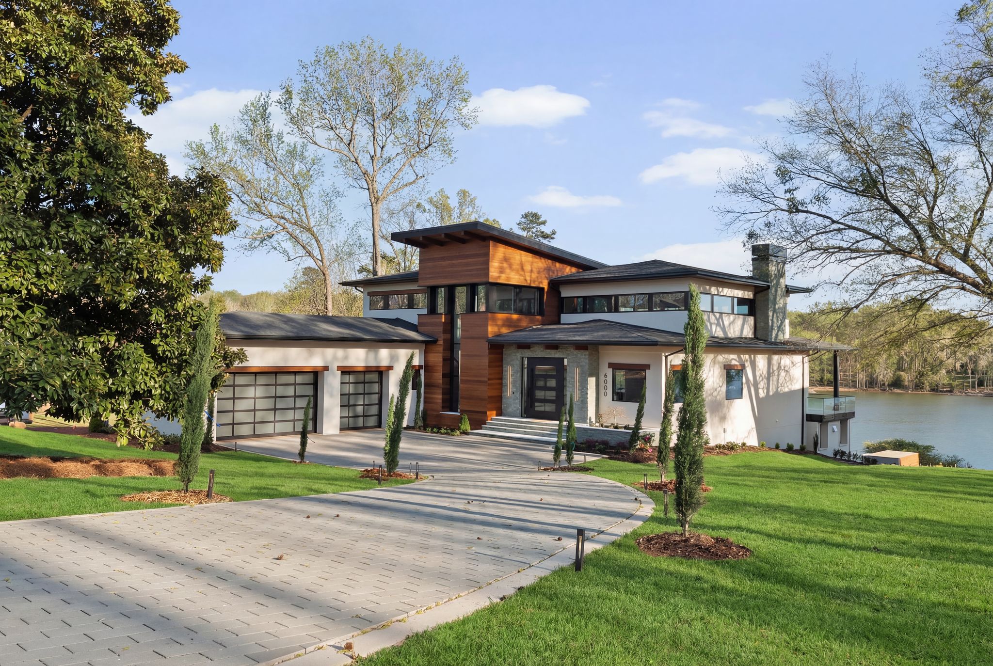 Modern waterfront home with warm wood siding and stone accents