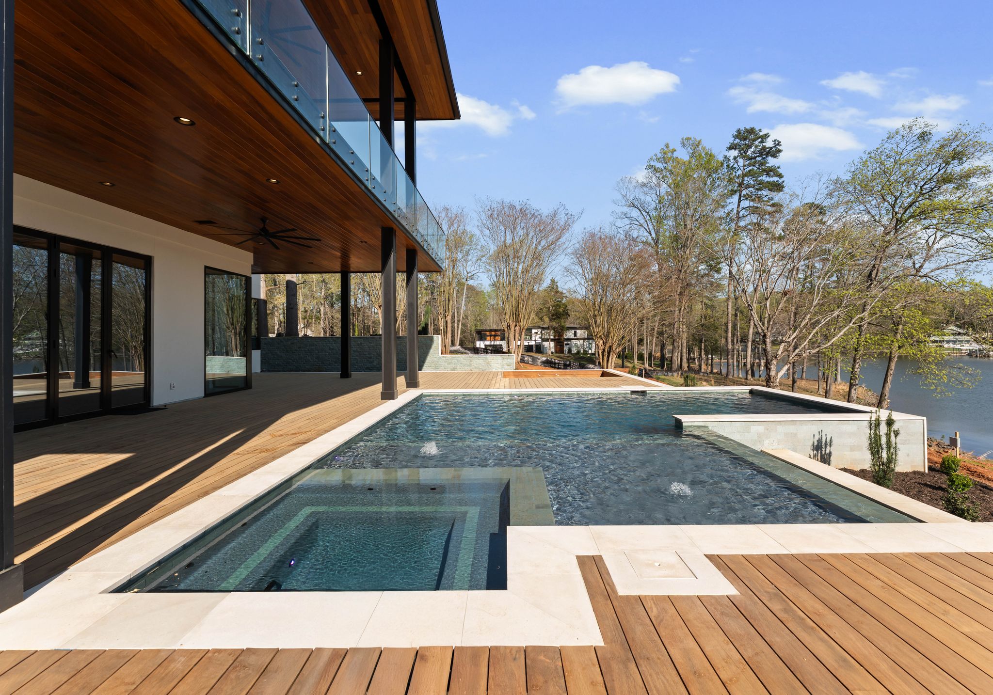 Wood ceilings and soffits beneath waterfront balconies beside a pool